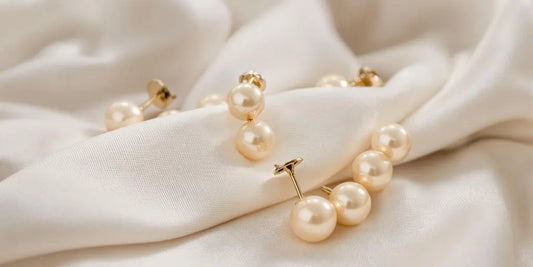 Elegant ball earrings on a soft fabric background.