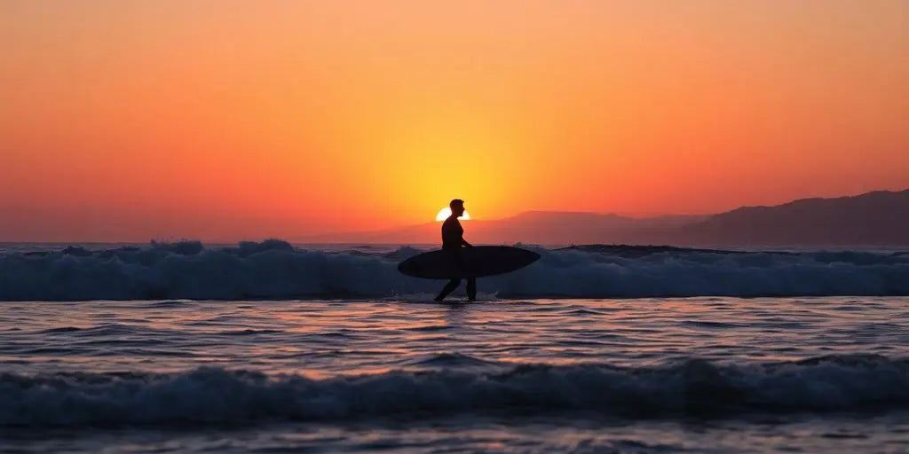 Surfer at Taghazout, Morocco during sunset.